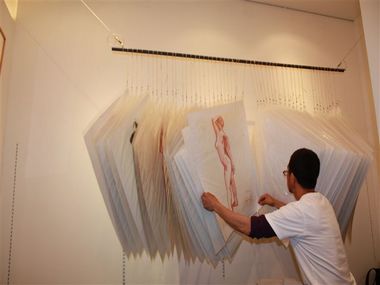 額装していない作品を吊るして展示する、ユニークな方法もとっています。 その数なんと50点!